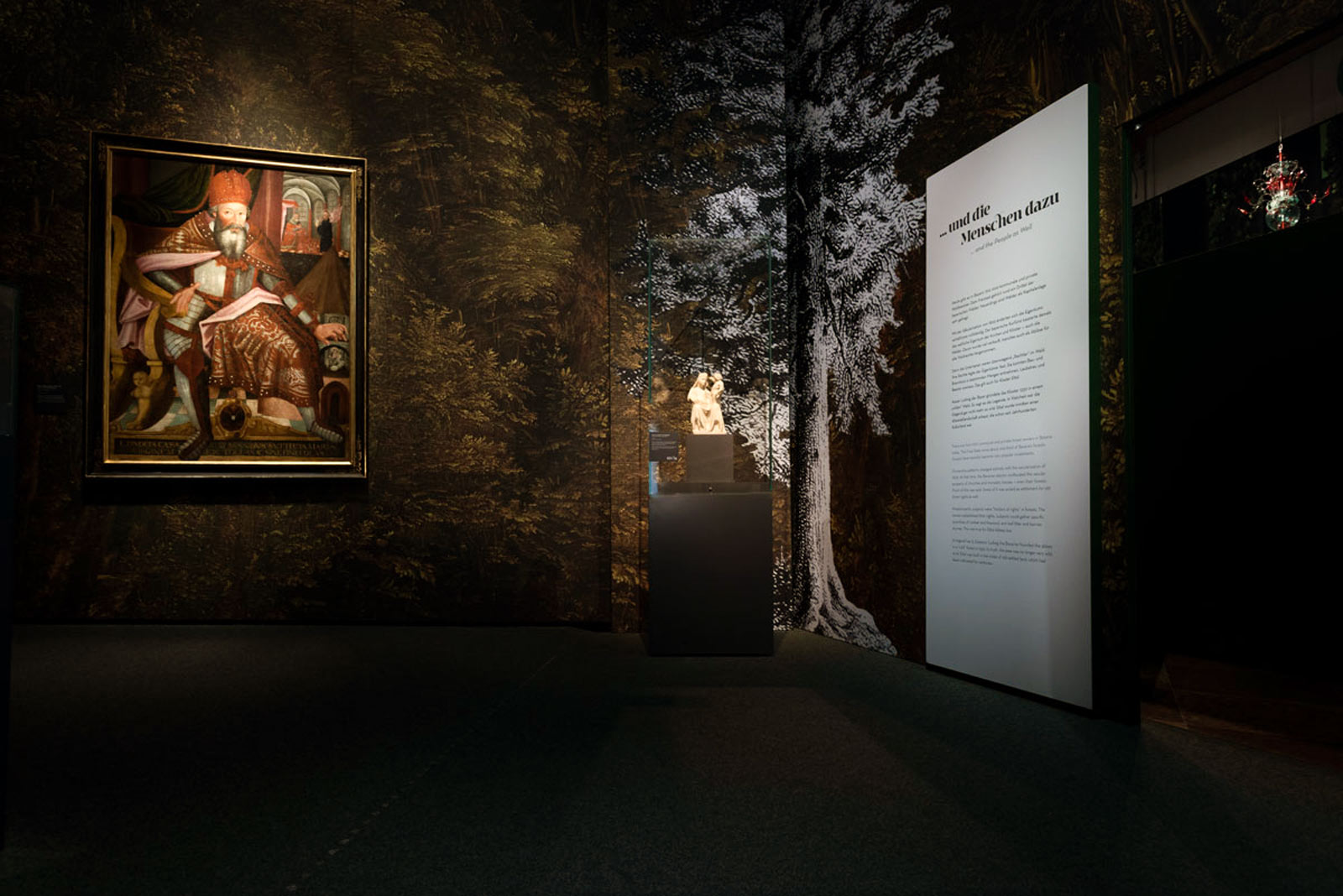Das Referenzbild für Ausstellungsgestaltung aus der Sonderausstellung Wald, Gebirg und Königstraum – Mythos Bayern zeigt eine Rauminszenierung mit Leuchtkästen und Vitrinen.