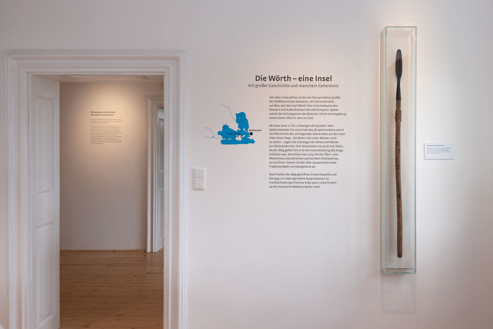 Das Referenzbild für Ausstellungsgestaltung aus der Dauerausstellung Seehausen und der Staffelsee zeigt eine Exponatpräsentation und eine Wandgrafik als Schablonierung.