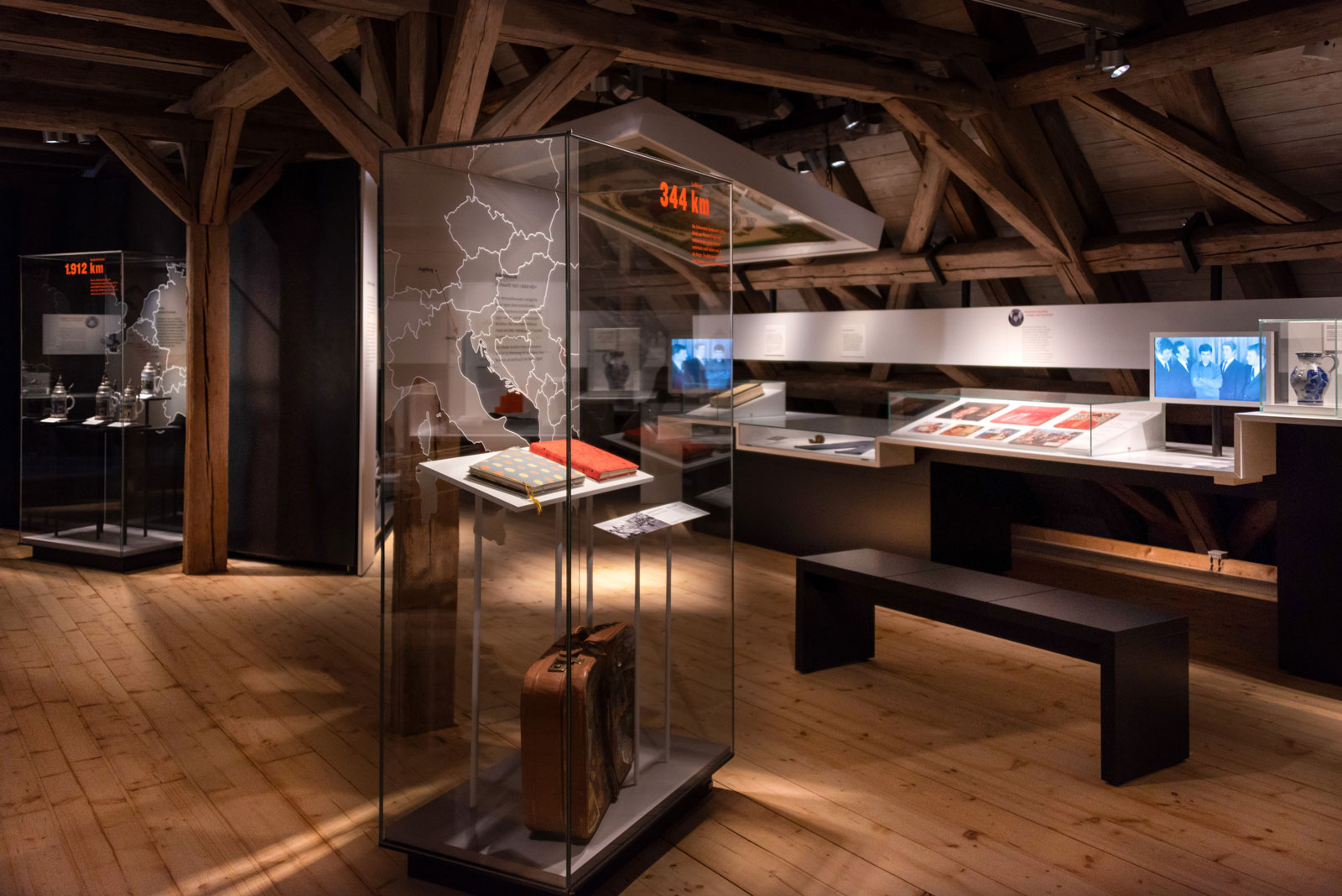 Das Referenzbild für Ausstellungsgestaltung aus der Dauerausstellung Tradition und Umbruch zeigt Ganzglas-Vitrinen.