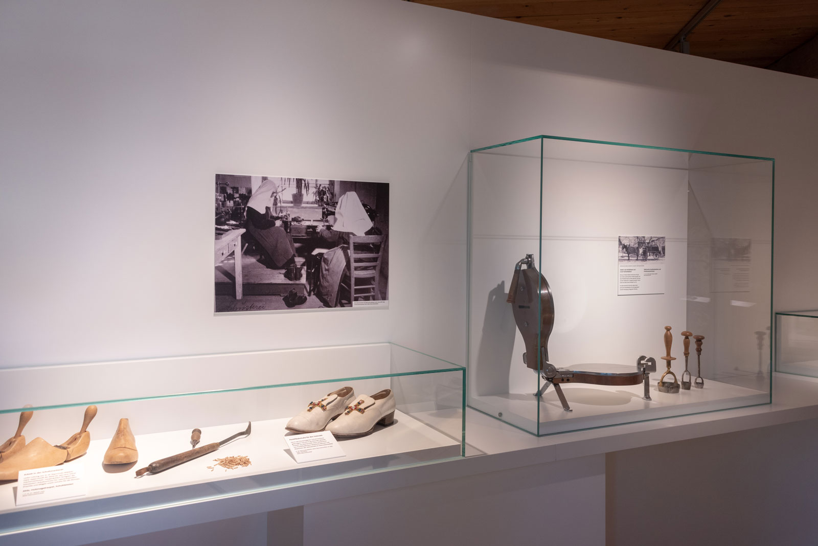 Das Referenzbild für Ausstellungsgestaltung aus der Dauerausstellung Tradition und Umbruch zeigt eine Exponatpräsentation mit Tischvitrinen und Vitrinenhaube.