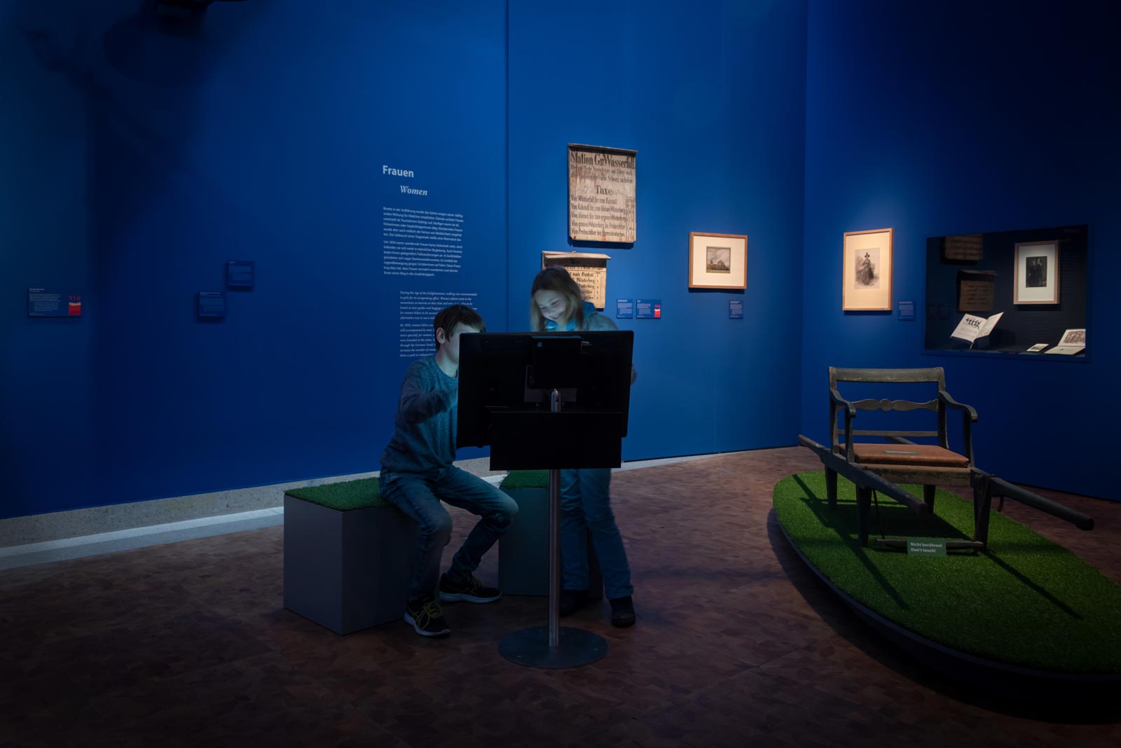 Das Referenzbild für Ausstellungsgestaltung aus der Sonderausstellung Wanderland zeigt eine barrierefreie Medienstation und Wandvitrinen.