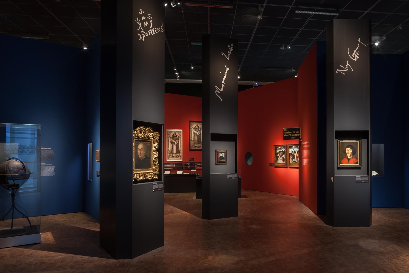 Das Referenzbild für Ausstellungsgestaltung aus der Sonderausstellung Luther, Kolumbus und die Folgen zeigt eine Szenografie mit Exponatpräsentation.