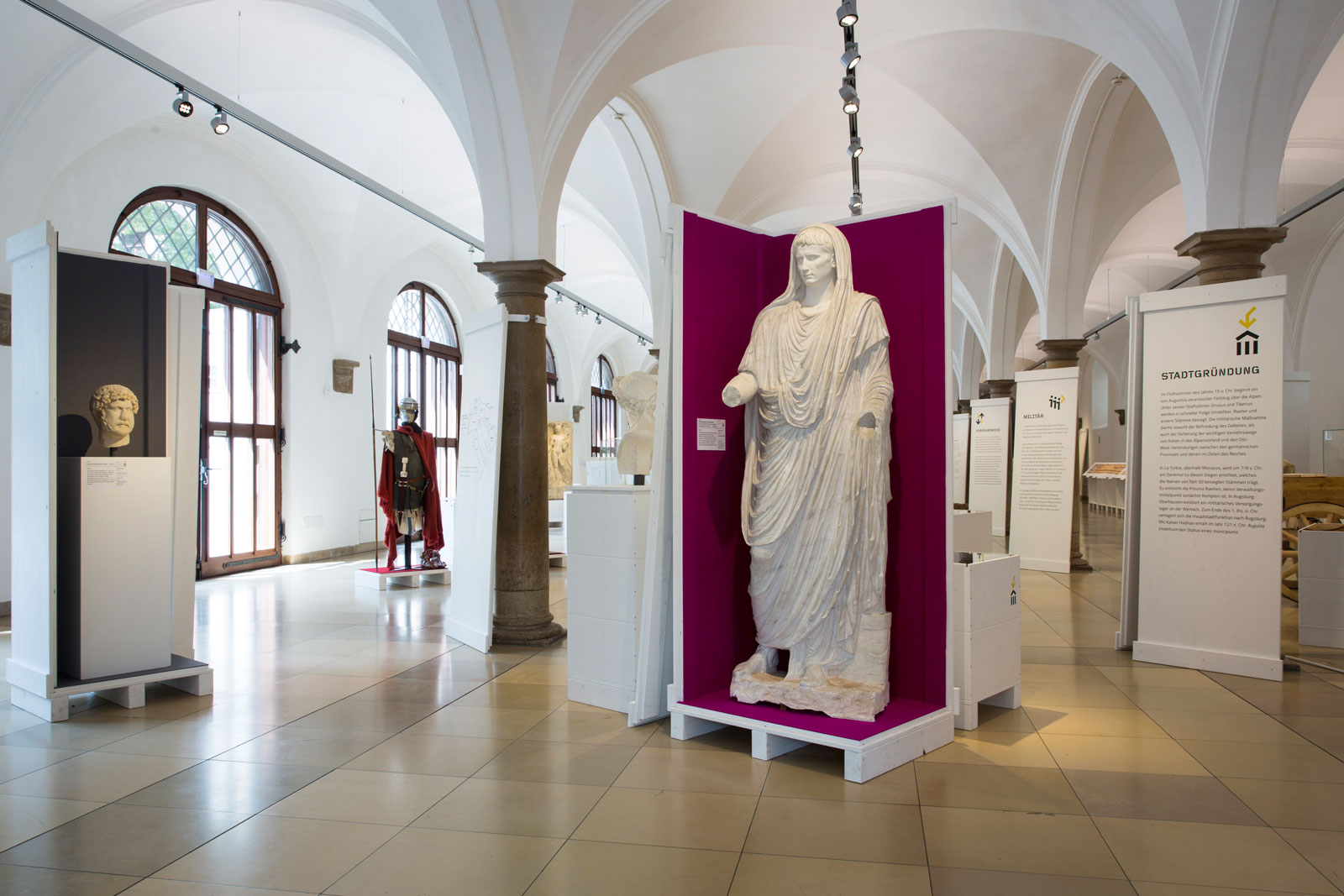Das Referenzbild für Ausstellungsgestaltung aus der Interimsausstellung „Römerlager – Das Römische Augsburg in Kisten“ zeigt eine Exponatpräsentation aus dem „Römischen Museum“.