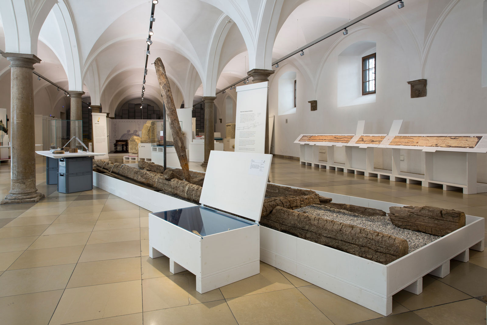 Das Referenzbild für Ausstellungsgestaltung aus der Interimsausstellung „Römerlager – Das Römische Augsburg in Kisten“ zeigt eine Exponatpräsentation in einer Vitrinenkiste.
