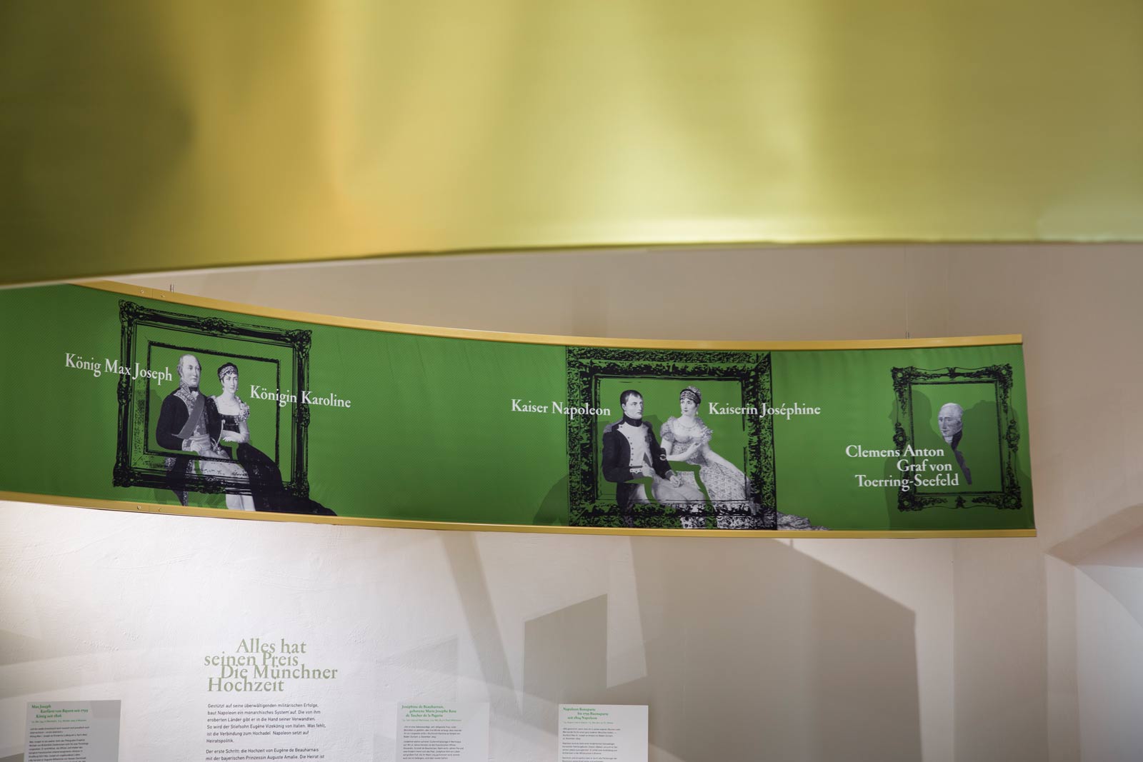 Das Referenzbild für Ausstellungsgestaltung aus der Sonderausstellung Napoleon und Bayern zeigt eine Rauminszenierung mit Textildruck und Ausstellungsgrafik.