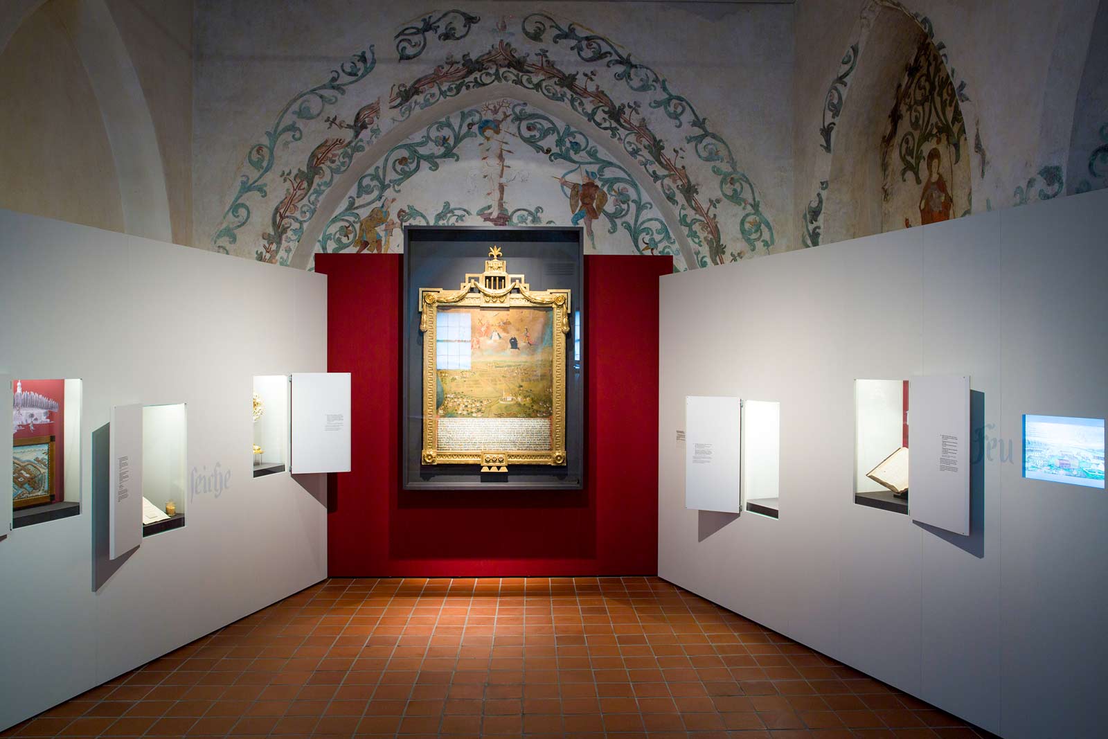 Das Referenzbild für Ausstellungsgestaltung aus der Sonderausstellung Napoleon und Bayern zeigt eine Aktivstation mit Wandvitrine im historischen Baubestand.