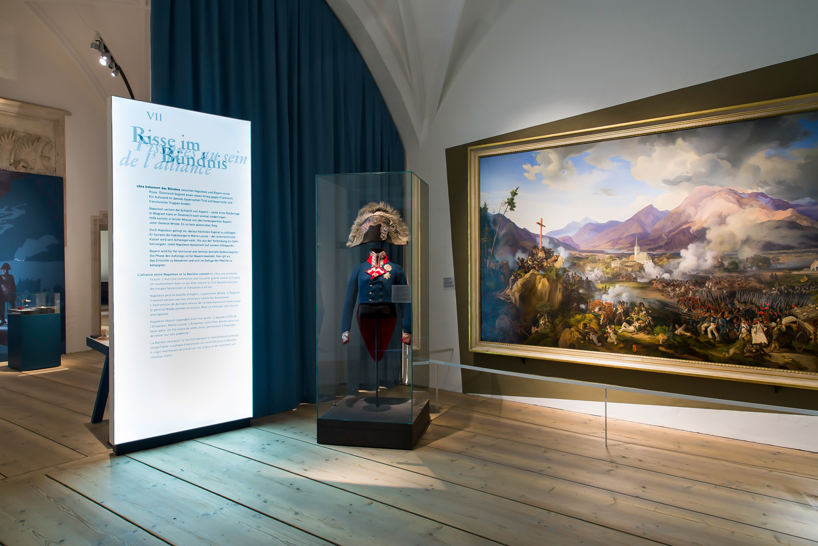 Das Referenzbild für Ausstellungsgestaltung aus der Sonderausstellung Napoleon und Bayern zeigt eine Szenografie mit Leuchtkästen und Ganzglasvitrine.