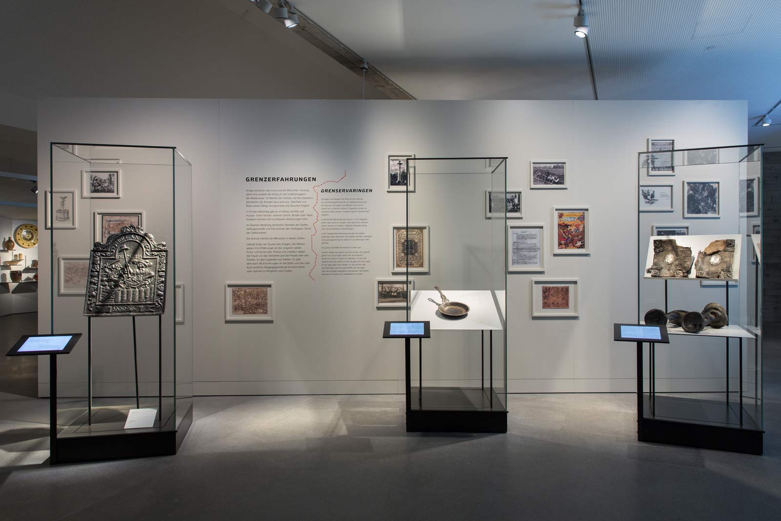 Das Referenzbild für Ausstellungsgestaltung aus der Dauerausstellung Grenze zeigt eine Medienstation mit Exponatpräsentation in Ganzglasvitrinen.